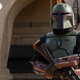 Boba Fett rests his arms across his blaster rifle in a scene from The Book of Boba Fett.